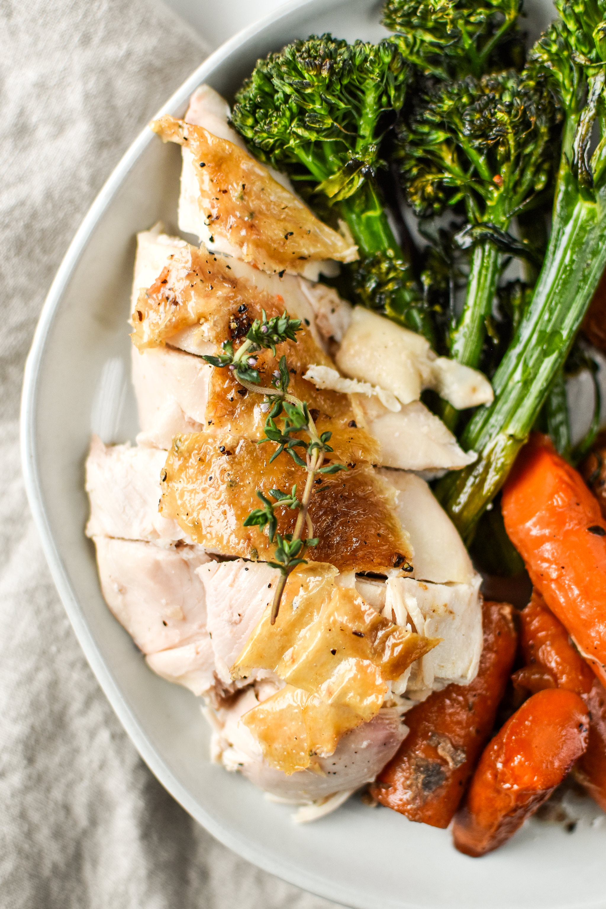 Simple whole roast chicken plated with vegetables for dinner.