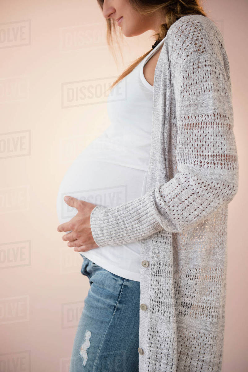 Pregnant Caucasian woman holding her belly - Stock Photo - Dissolve