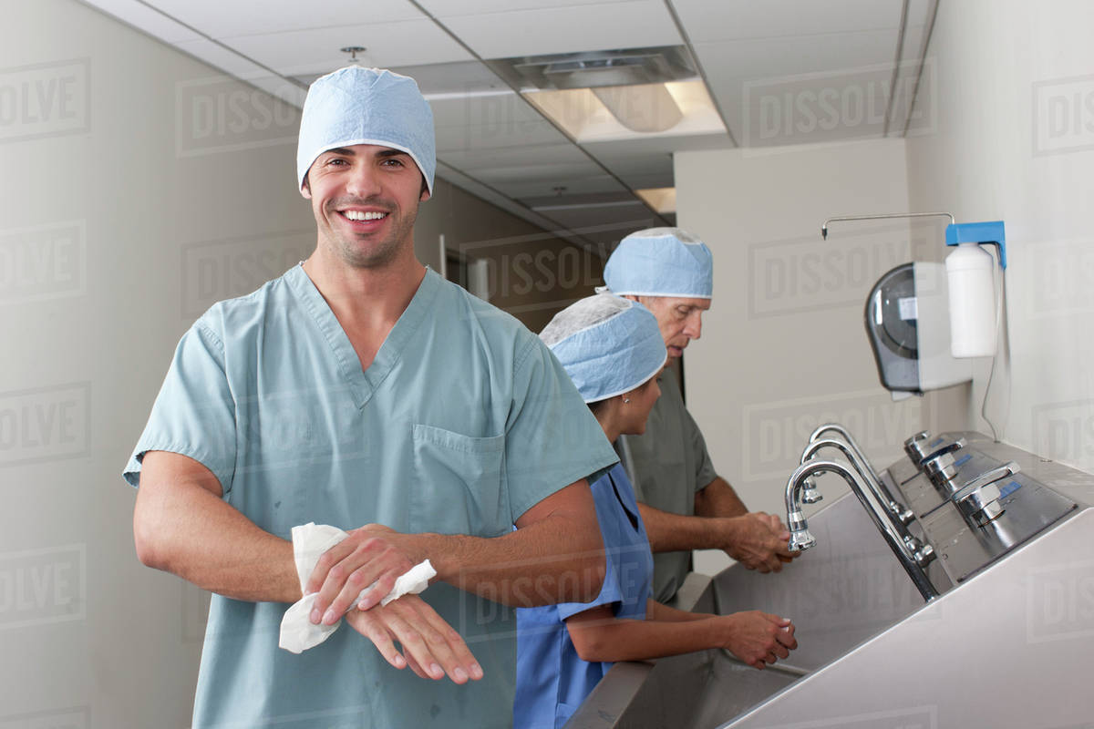 Surgeons washing hands in hospital - Stock Photo - Dissolve