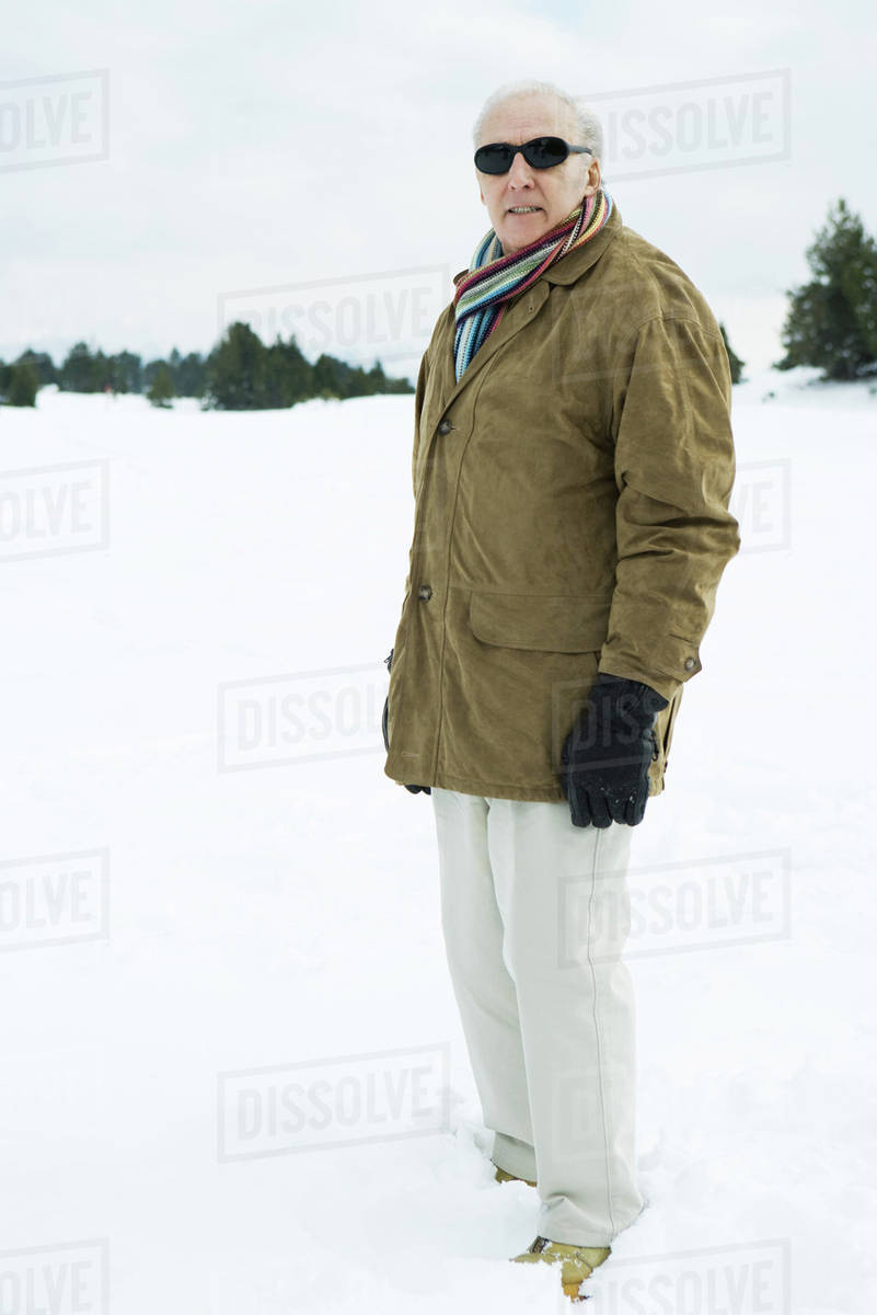 Senior man standing in snow, looking at camera, portrait - Stock Photo ...