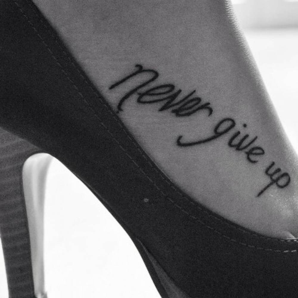 "Never give up" tattoo on Anna's foot.