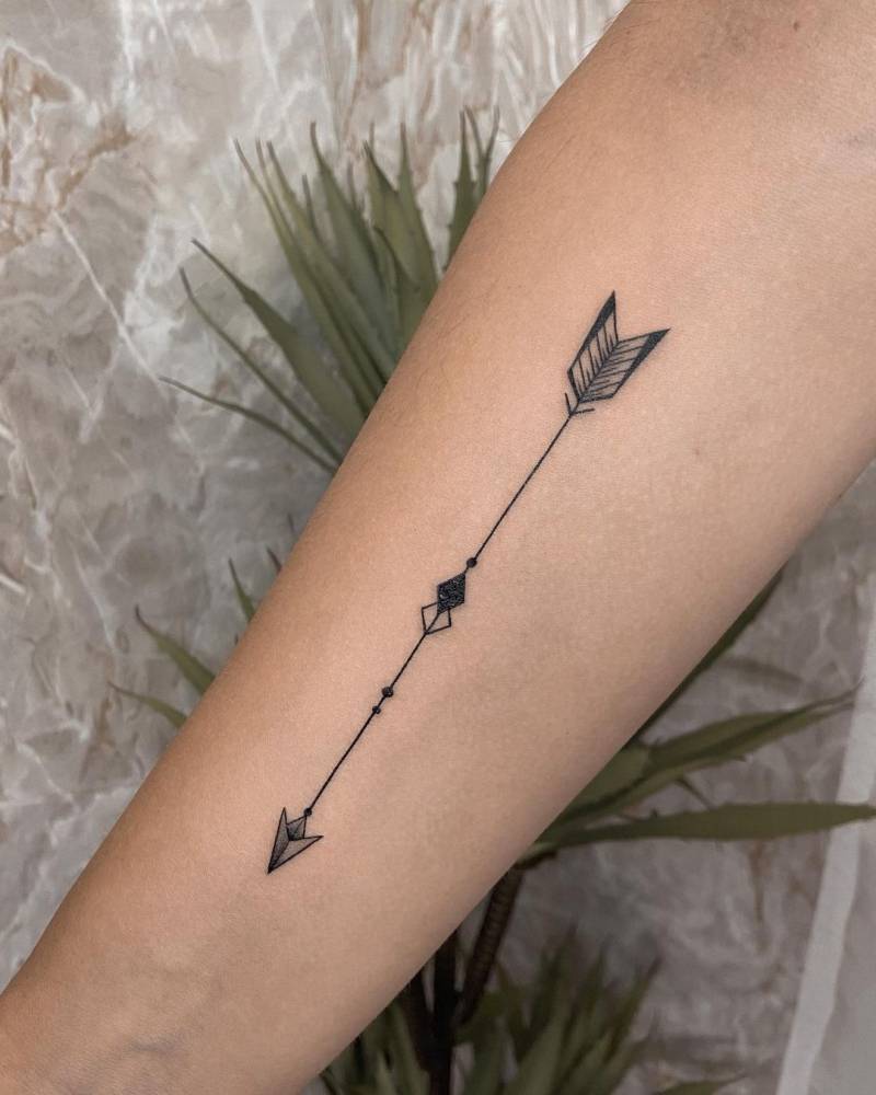 Fine line arrow tattoo on the inner forearm.