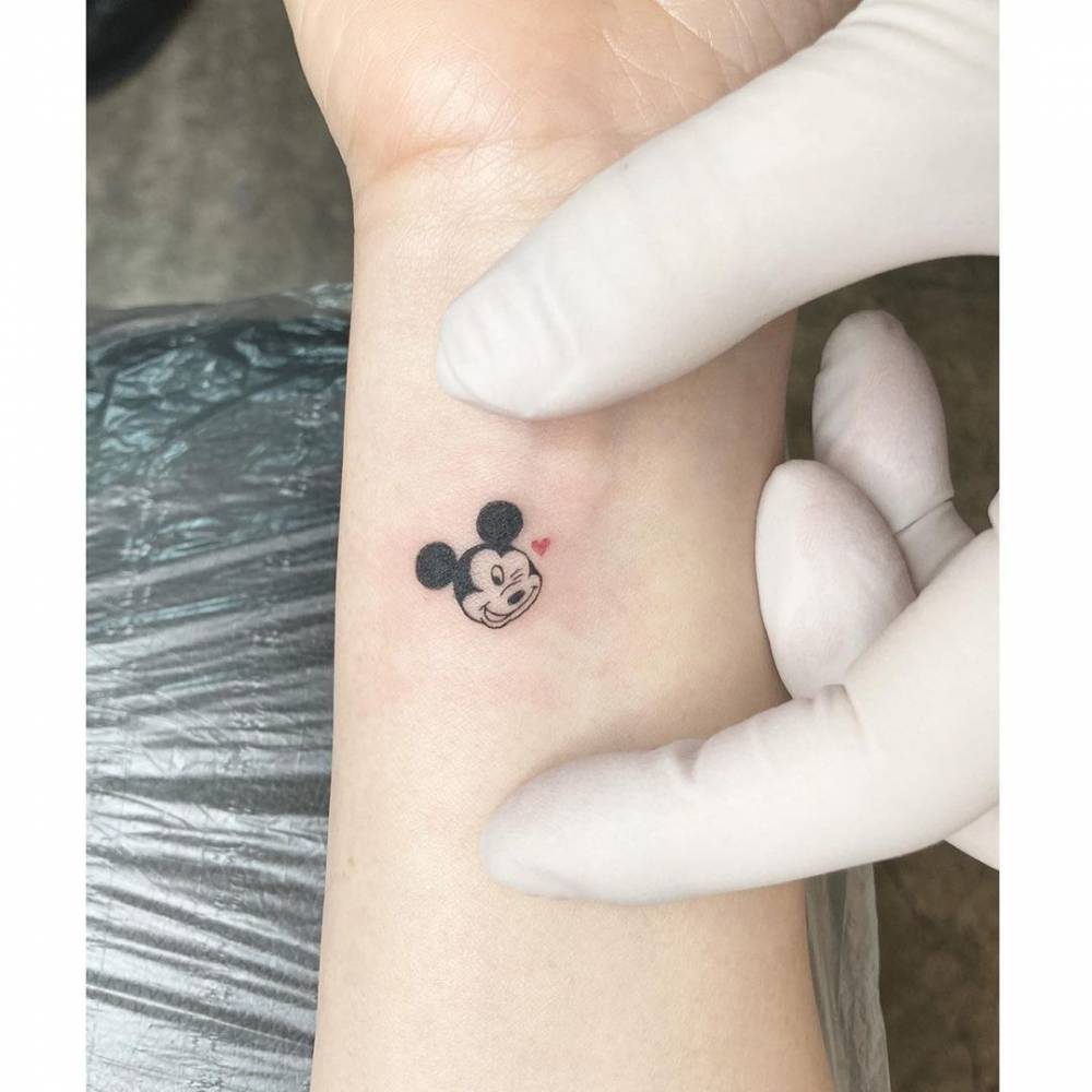 Mickey mouse tattoo on the wrist.