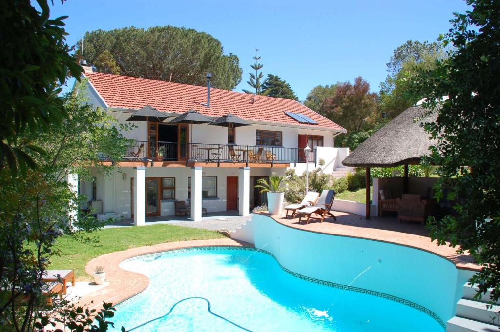 a villa with a swimming pool and a house at Villa Helderberg in Somerset West