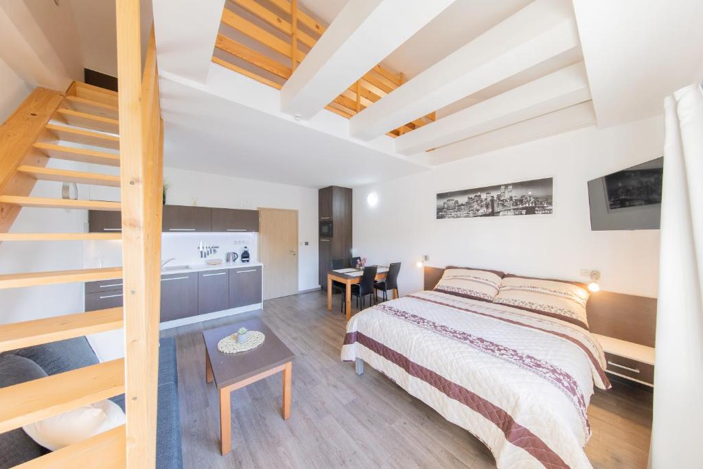 1 dormitorio con 1 cama y escalera. en Apartmány Sophia 7, en Velké Losiny