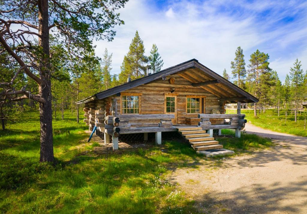 a log cabin in the woods with a tree at Arctic Log Cabins in Saariselka