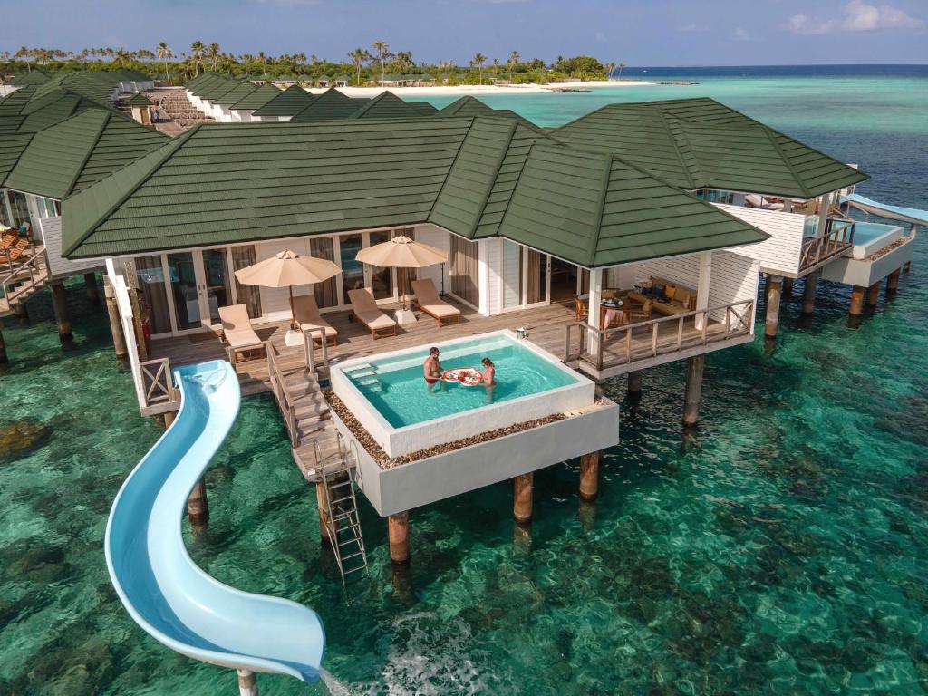 a house on the water with a pool and a slide at Siyam World Maldives - 24-Hour Premium All-inclusive with Free Transfer in Dhigurah