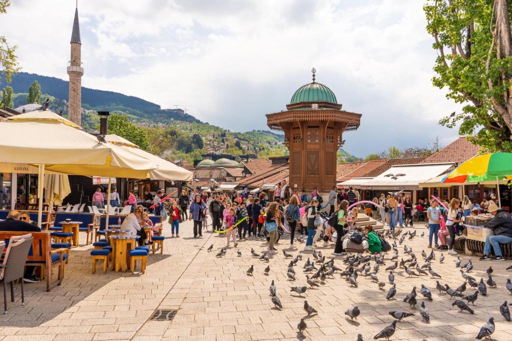 a group of birds on a street in a market at Bascarsija Guesthouse - Private Bath, TV & AirCon in Sarajevo