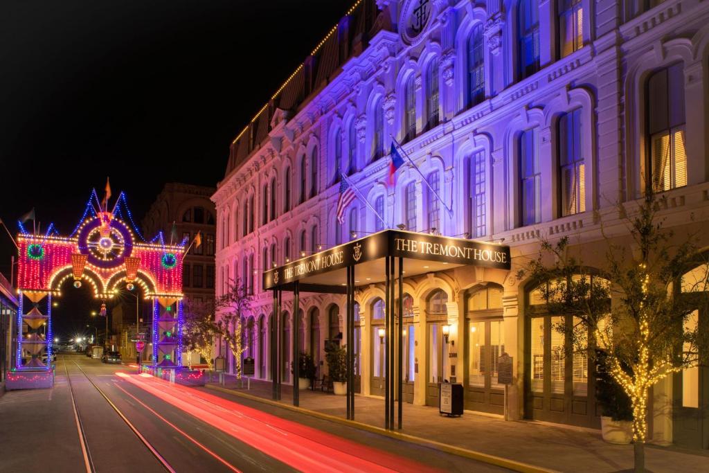 The Tremont House, Galveston, a Tribute Portfolio Hotel في جالفيستون: شارع المدينة فيه عمارة مضاءة بالليل