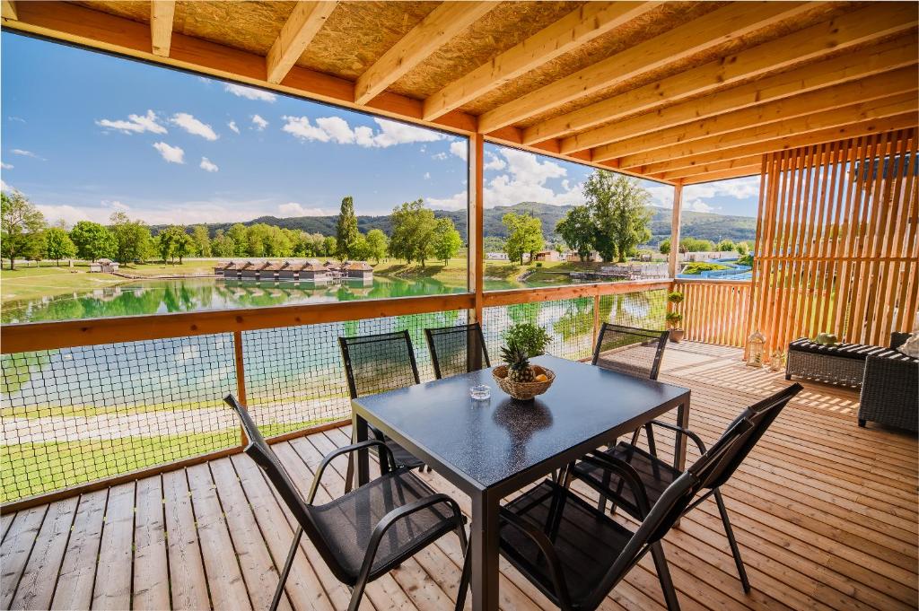 uma mesa e cadeiras num deque com vista em DELUXE Lake View Mobile Homes with Thermal Riviera Tickets em Čatež ob Savi