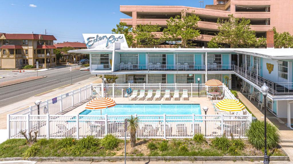 a building with a swimming pool and two umbrellas at Eden Roc Motel in Ocean City