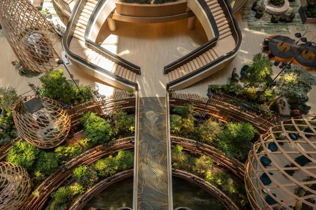 an overhead view of a mall with escalators and trees at PARKROYAL COLLECTION Marina Bay, Singapore in Singapore