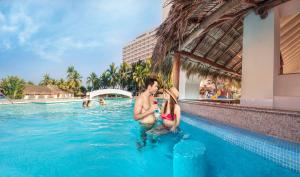 a man and a woman in the swimming pool at a resort at Park Royal Beach Ixtapa - All Inclusive in Ixtapa