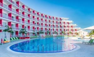 a hotel with a swimming pool in front of a building at Grand Decameron Cornwall Beach, A Trademark All-Inclusive Resort in Montego Bay