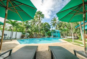 uma piscina com cadeiras e guarda-sóis em Bohol Sea Resort em Panglao City