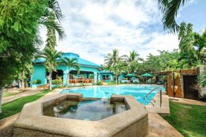 uma piscina com uma fonte em frente a uma casa em Bohol Sea Resort em Panglao City