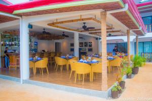 a restaurant with tables and chairs and people sitting at them at Alona Vida Beach Hill Resort in Panglao Island