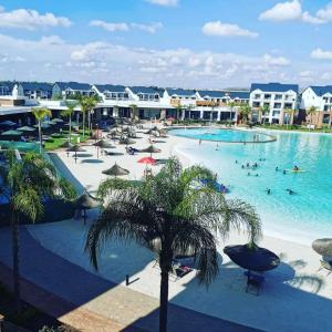 a large swimming pool with people in a resort at Lush Living The Blyde Riverwalk Estate Unit 101 in Pretoria