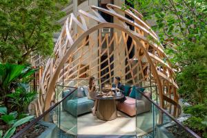 two people sitting at a table under an archway in a garden at PARKROYAL COLLECTION Marina Bay, Singapore in Singapore