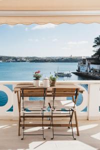 een tafel en stoelen op een balkon met uitzicht op het water bij Fonduco in Mahón