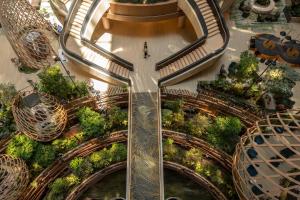 an overhead view of a mall with escalators and trees at PARKROYAL COLLECTION Marina Bay, Singapore in Singapore