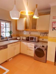 a kitchen with white cabinets and a dishwasher at Enjoy Beloura! in Sintra