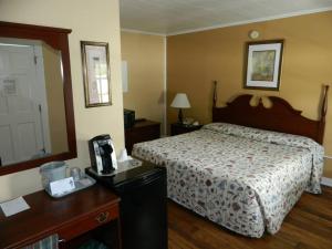 a hotel room with a bed and a mirror at Belle Isle Motel in Bar Harbor