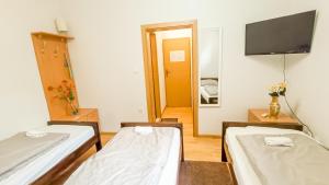 a room with two beds and a flat screen tv at Bascarsija Guesthouse - Private Bath, TV & AirCon in Sarajevo