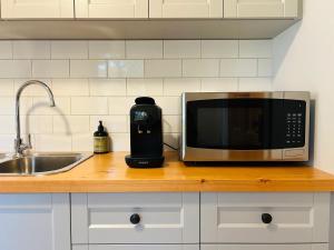 a microwave sitting on a counter next to a sink at Willunga Gallery Cabins in Willunga