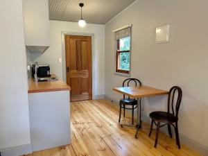 a kitchen with a table and chairs in a room at Willunga Gallery Cabins in Willunga