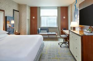 a hotel room with a bed and a desk and a chair at Renaissance Atlanta Midtown Hotel in Atlanta