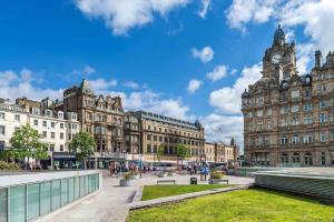 een groot gebouw met een klokkentoren in een stad bij Motel One Edinburgh-Princes in Edinburgh