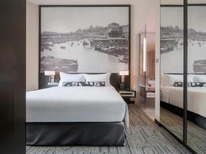 a bedroom with a large bed and a large painting of a river at The Robertson House managed by The Ascott Limited in Singapore