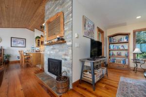 a living room with a stone fireplace and a desk at Siletz Bay Beach House in Lincoln City