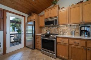 a kitchen with wooden cabinets and a stove top oven at Siletz Bay Beach House in Lincoln City