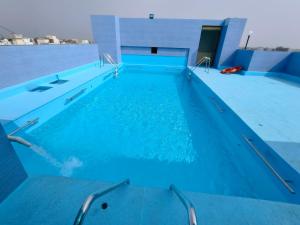 a swimming pool with blue water in a building at Hotel City Heart Shirdi in Shirdi