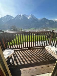 un banco en una terraza con montañas al fondo en Grazioso appartamento 1, en Aosta