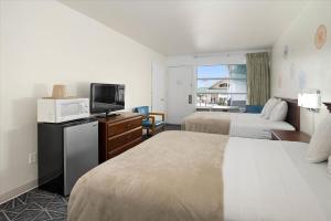 a hotel room with two beds and a flat screen tv at Eden Roc Motel in Ocean City