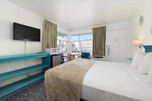 a hotel room with a large bed with a flat screen tv at Eden Roc Motel in Ocean City