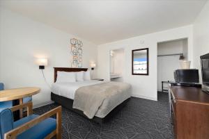 a hotel room with a bed and a flat screen tv at Eden Roc Motel in Ocean City