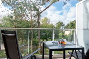 d'une table noire et d'une chaise sur un balcon avec fenêtre. dans l'établissement Apartamenty In Mestwina 37 Jurata, à Jurata