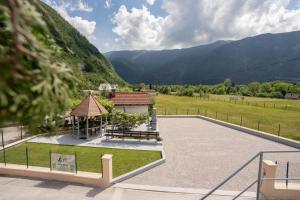 um parque com um gazebo e um edifício com montanhas em Relax House Soča em Bovec