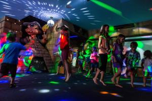 a group of people dancing in a room with lights at Paradise Resort Gold Coast in Gold Coast