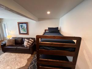 una camera con 2 letti a castello e un divano di Beautifully Remodeled Condo at Mammoth Ski & Racquet Club, Hot Tub, Garage, 10 Min Walk to Ski Lifts a Mammoth Lakes