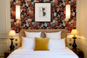 a bedroom with a bed with a floral wallpaper at Hôtel Bristol Pau in Pau