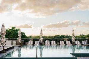 a hotel pool with chairs at THesis Hotel Miami Coral Gables, Curio Collection by Hilton in Miami