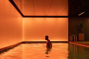 a man standing in a swimming pool at art'otel London Hoxton in London