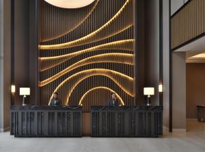 two men in front of a wall with lights at Courtyard by Marriott Siliguri in Siliguri