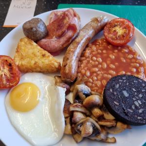 a plate of breakfast food with eggs beans and mushrooms at Trevarrian Lodge in Newquay