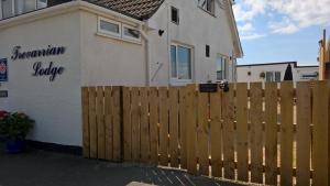 a wooden fence in front of a house at Trevarrian Lodge in Newquay